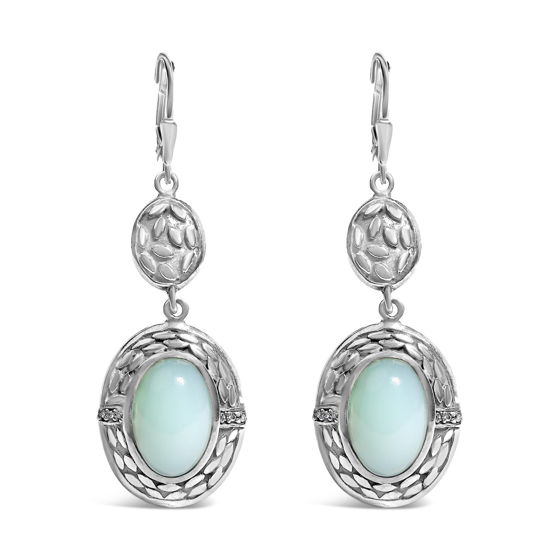 Front view of a pair of white metal dangle earrings featuring an oval gray gemstone in a bezel setting surrounded by decorative detailing and small round white gemstones in prong settings.