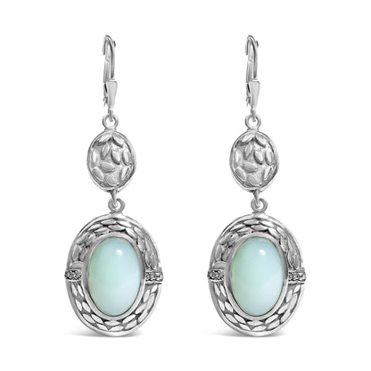 Front view of a pair of white metal dangle earrings featuring an oval gray gemstone in a bezel setting surrounded by decorative detailing and small round white gemstones in prong settings.