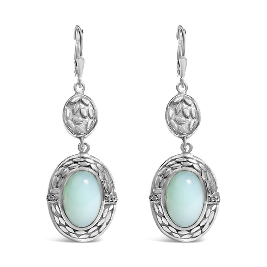 Front view of a pair of white metal dangle earrings featuring an oval gray gemstone in a bezel setting surrounded by decorative detailing and small round white gemstones in prong settings.