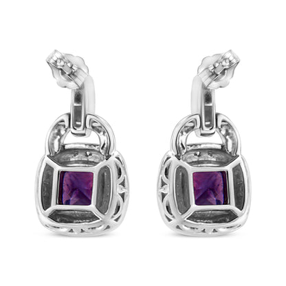 Front view of white metal earrings with cushion-shaped purple gemstones in the center, surrounded by pave-set round white gemstones.