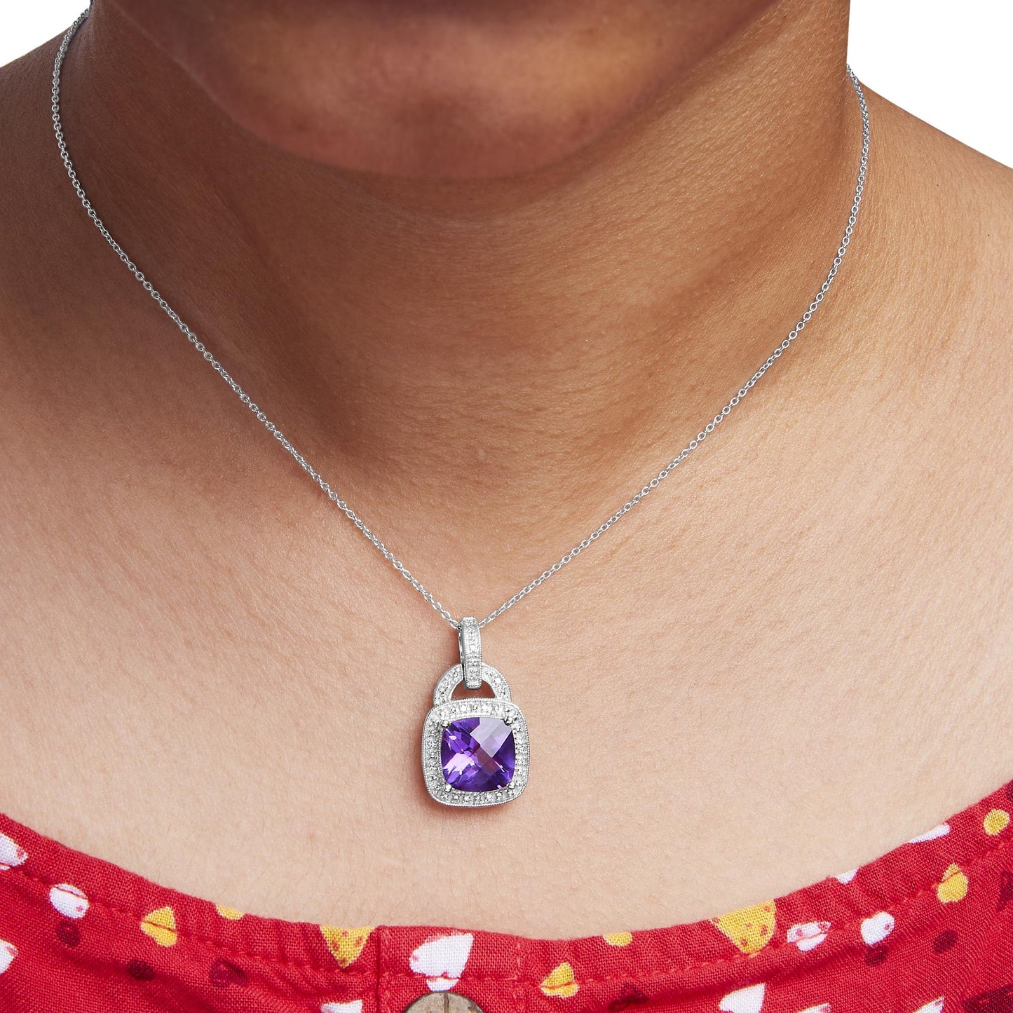 Close-up front view of a white metal necklace on a model, featuring a pendant with a purple cushion-shaped gemstone surrounded by small round white gemstones in a pave setting.
