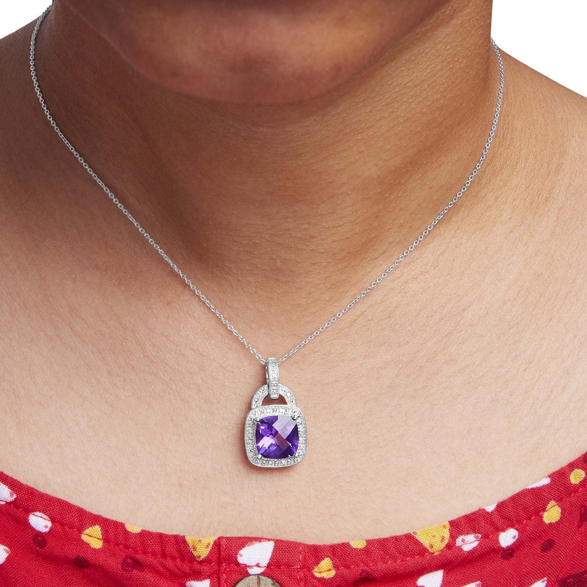 Close-up front view of a white metal necklace on a model, featuring a pendant with a purple cushion-shaped gemstone surrounded by small round white gemstones in a pave setting.