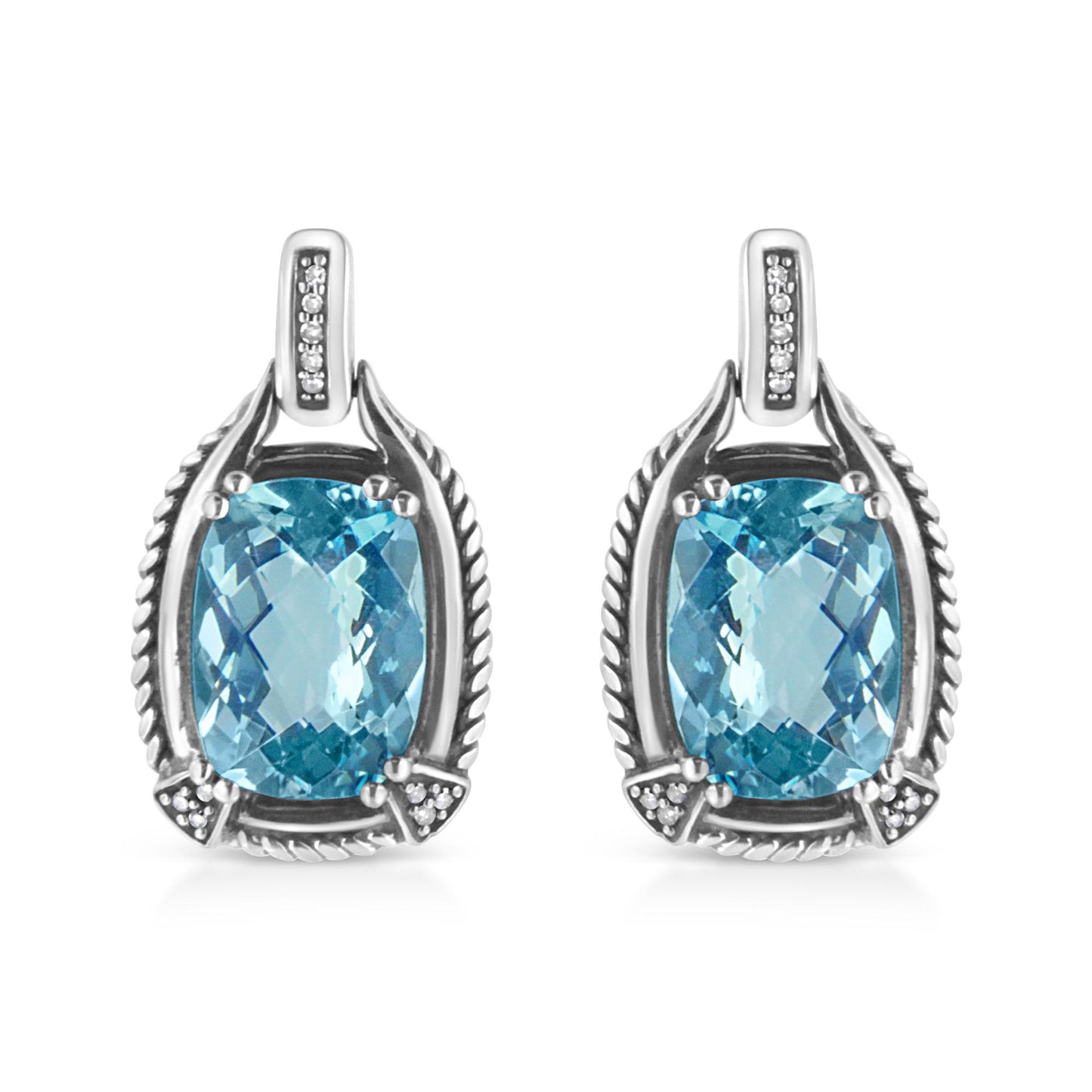Front view of white metal earrings featuring cushion-shaped blue gemstones in prong settings surrounded by round white gemstones in invisible settings.