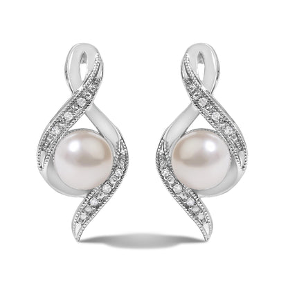 Close-up front view of a pair of white metal earrings with an abstract loop design accented with pave white gemstones and a large round pearl at the base, shown on a white background.