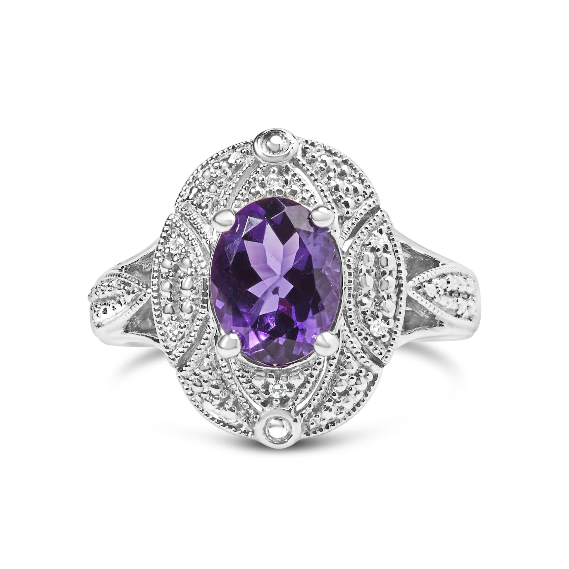 Front-facing shot of a white metal ring featuring an oval purple gemstone in the center with surrounding round white gemstones in prong settings.