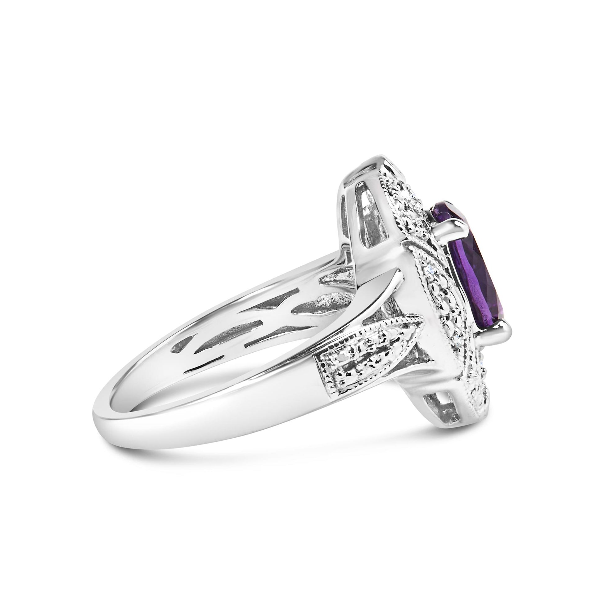 Side angle view of a white metal ring with an oval purple gemstone in a four-prong setting, surrounded by six round white gemstones in prong settings.