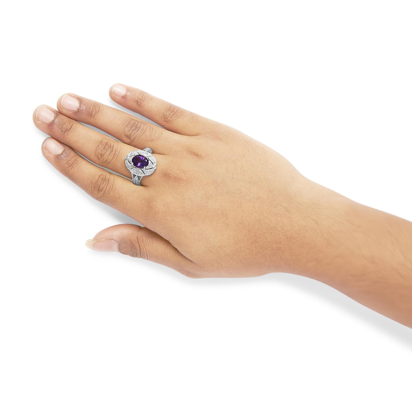 White metal ring with a purple oval gemstone surrounded by white round gemstones, worn on a model’s hand, top view angle.
