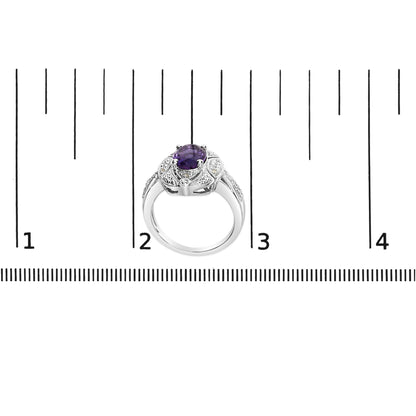 White metal ring with a central oval purple gemstone set in four prongs, surrounded by six round white gemstones in prong settings, shown from the front on a ruler for size reference.