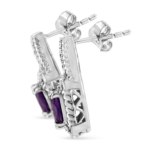 Close-up side angle of white metal earrings with oval purple gemstones in prong settings and multiple round white gemstones in pave settings.
