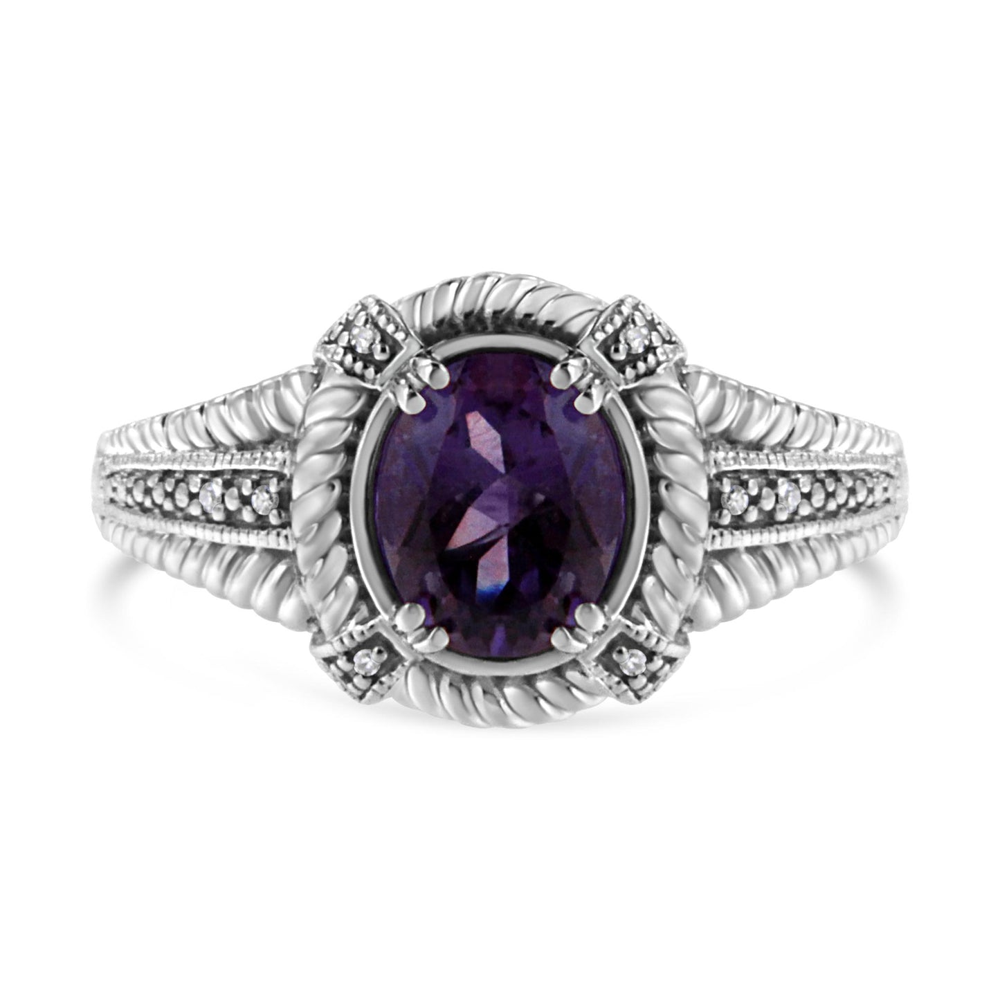 Front view of a white ring with an oval purple gemstone center, surrounded by eight round white gemstones in a pave setting on the band and around the center stone.