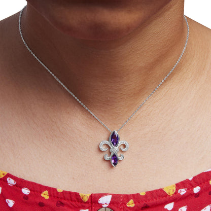 Close-up front view of a white necklace on a model featuring a fleur-de-lis pendant with two marquise-shaped purple gemstones in bezel settings and surrounded by round white gemstones in prong settings.