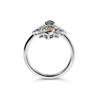 White metal ring with round white gemstones in pave setting and two marquise-shaped orange gemstones in bezel settings, shown from the side angle on a white background.