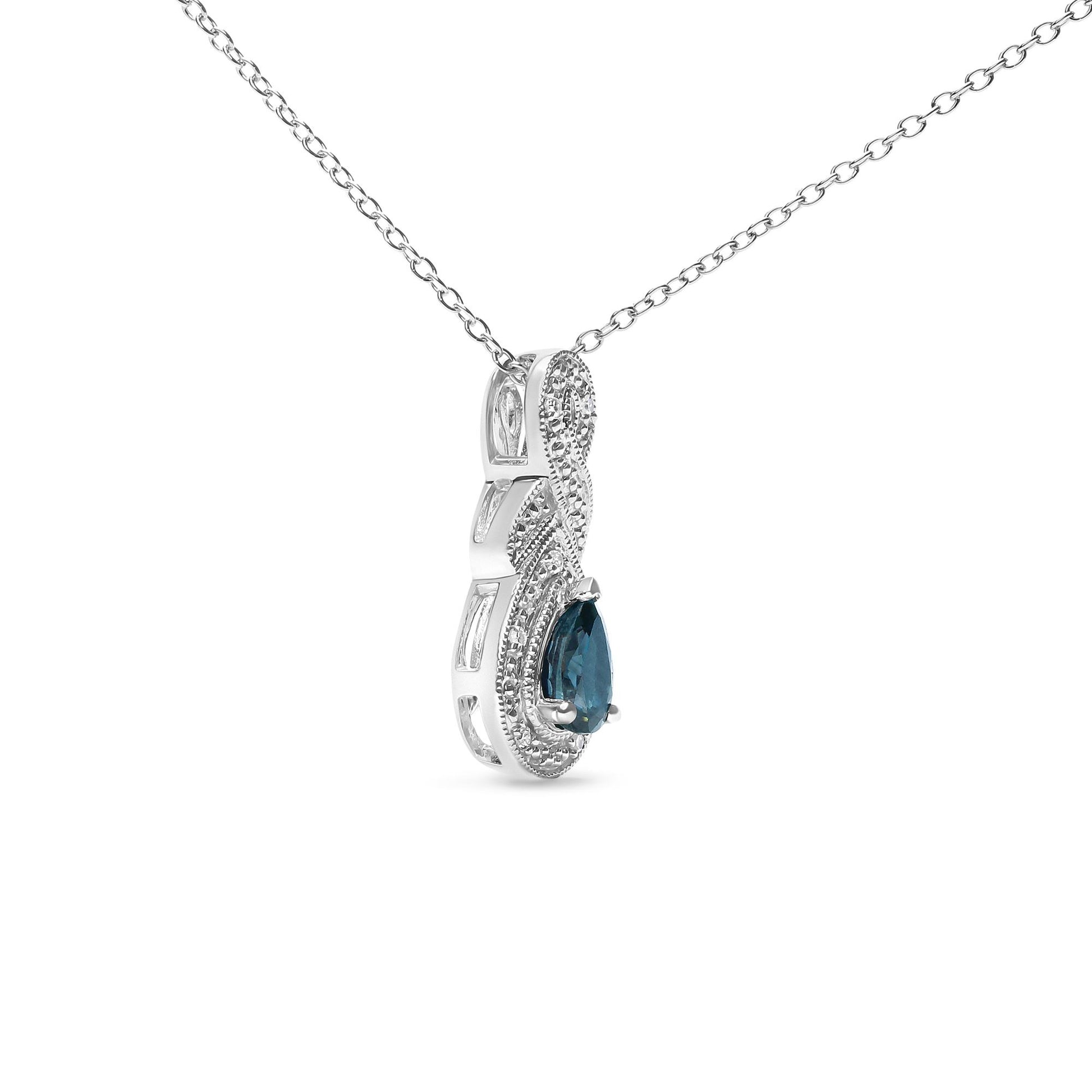 White metal necklace with a pendant featuring a pear-shaped blue gemstone surrounded by round white gemstones, shown in a close-up front angle.
