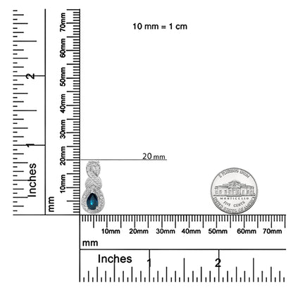 White necklace pendant with a pear-shaped blue gemstone surrounded by round white gemstones, prong set, shown on a ruler and scale for size reference, front angle.