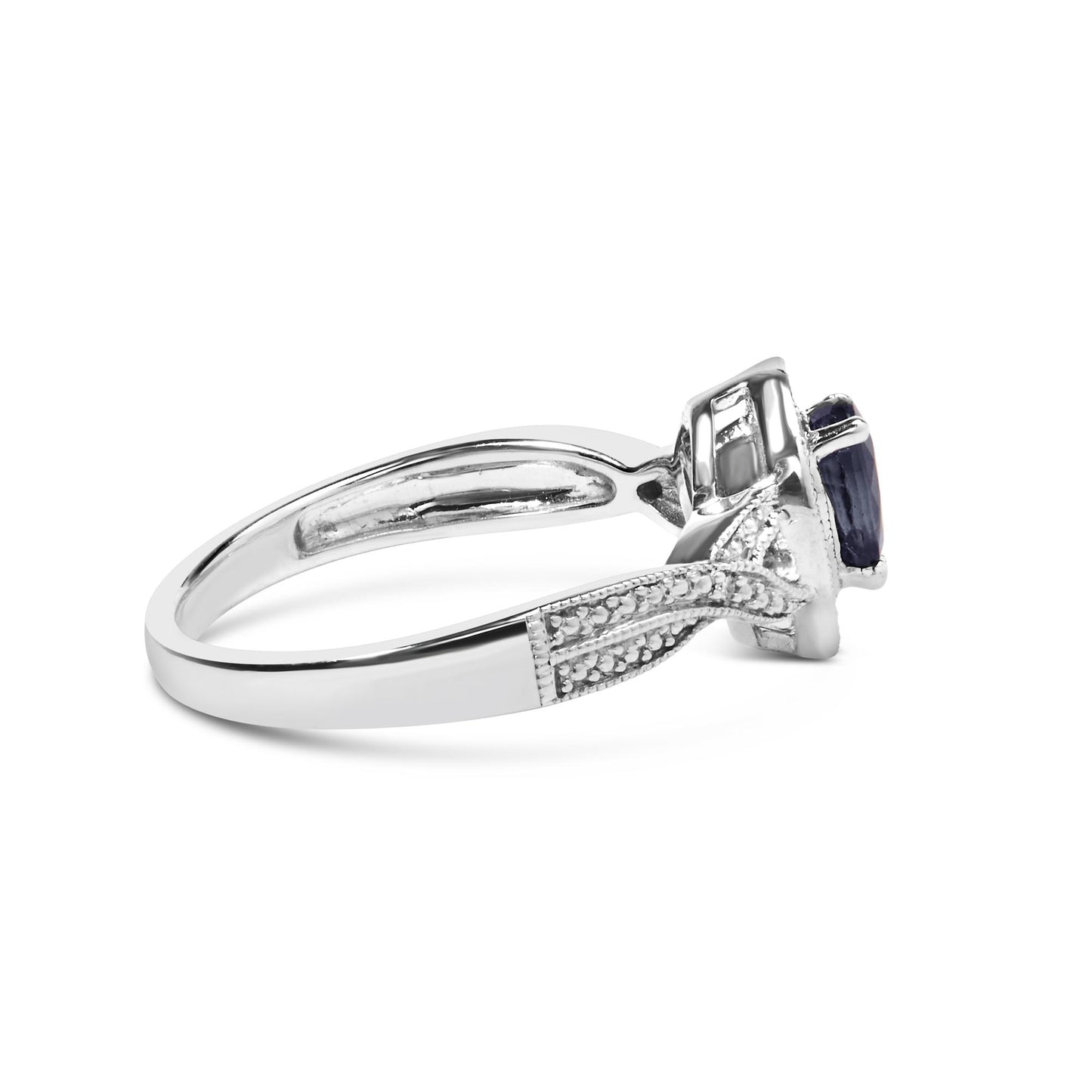 Side view of a white metal ring featuring a pear-shaped blue gemstone and surrounding round white gemstones in prong settings.