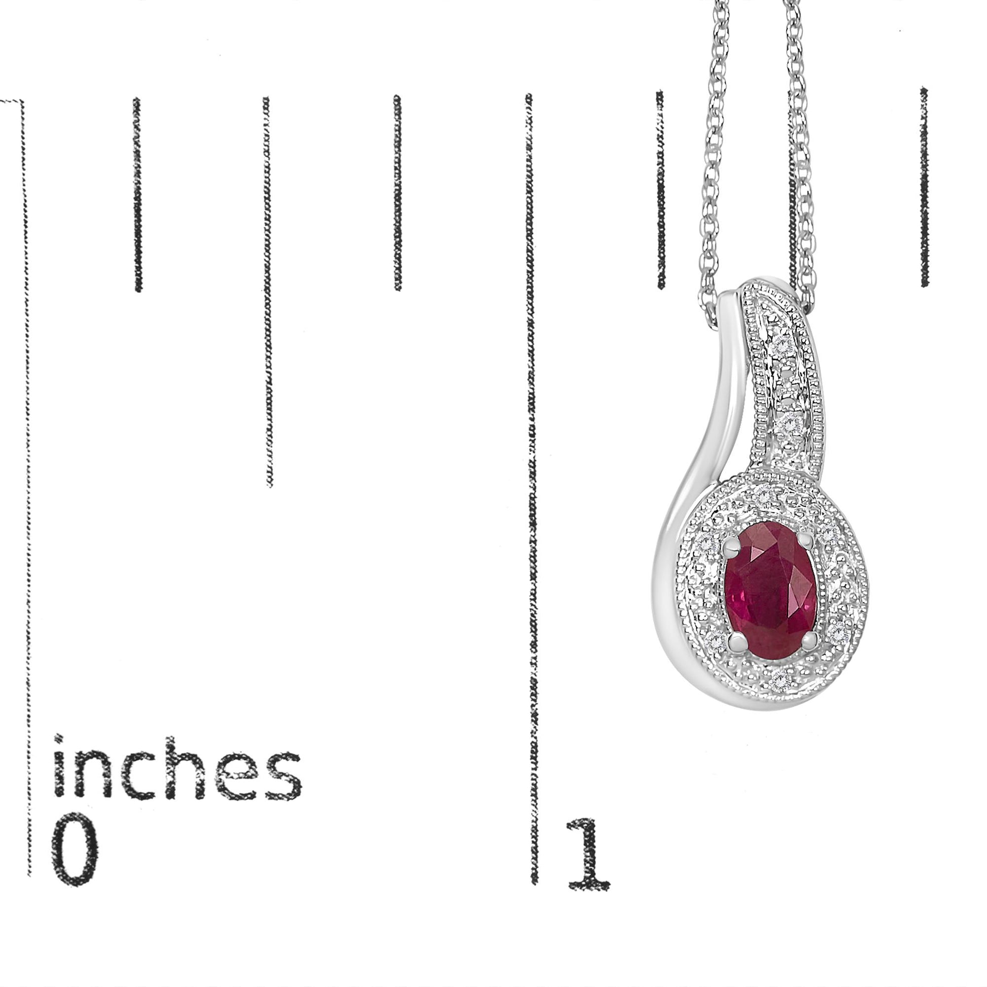 Close-up of a white metal necklace pendant with an oval red gemstone at the center, surrounded by small white gemstones in pave and prong settings, shown hanging on a measuring scale.