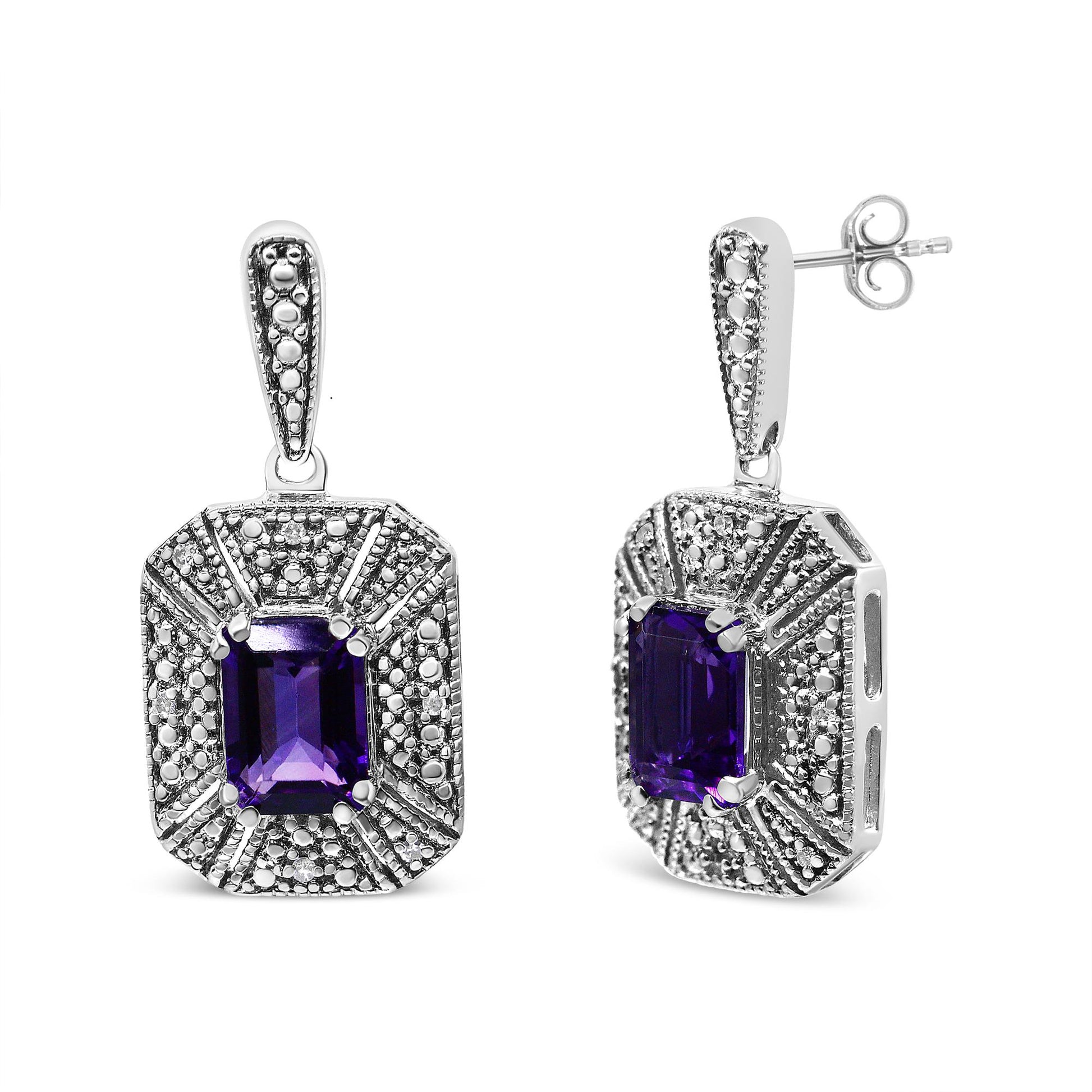 Pair of white metal earrings with purple emerald-shaped gemstones in center and surrounding round white gemstones, one earring shown from front and the other at a slight side angle.