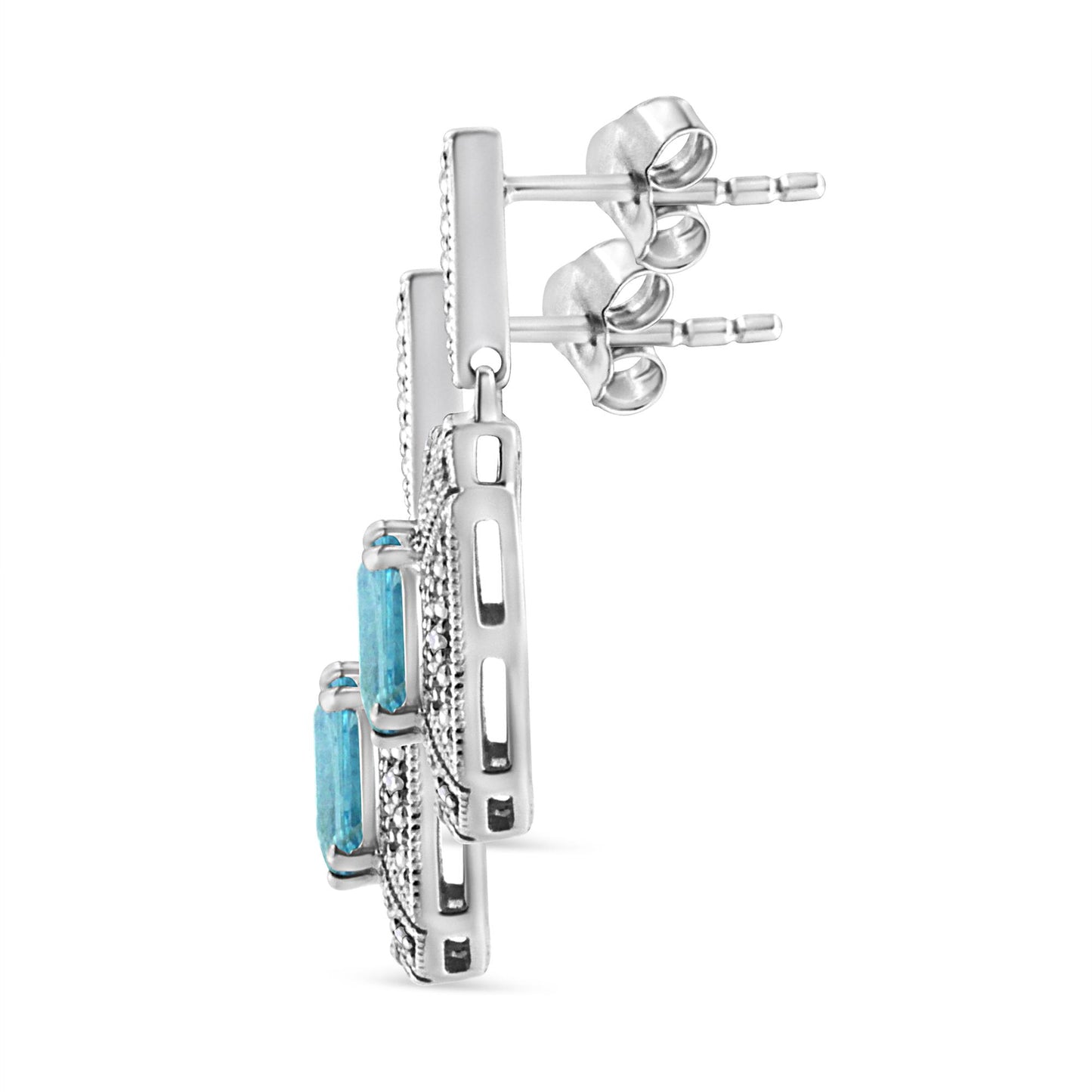 Side view of white metal earrings with blue gemstone in prong setting and surrounding white gemstones in pave setting.