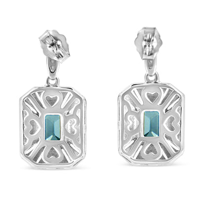 Front-facing view of white metal earrings with openwork heart and line patterns, each featuring a central blue rectangular gemstone in a prong setting.