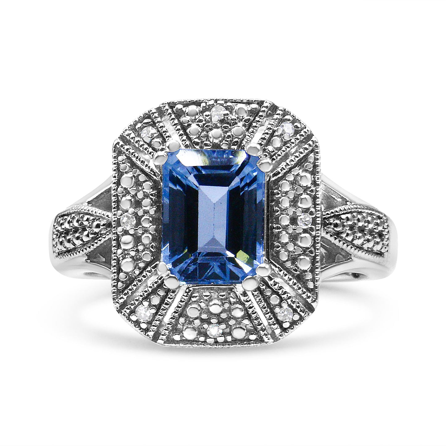 Front angle white metal ring with a large blue emerald-shaped gemstone in the center, surrounded by smaller round white gemstones in a detailed setting.