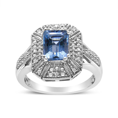 Front-facing shot of a white metal ring with a rectangular blue gemstone in the center, surrounded by white round gemstones in prong settings.