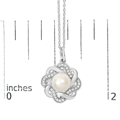 Close-up front view of a white necklace pendant featuring a central round pearl surrounded by intertwined loops accented with small round white gemstones, shown on a scale.