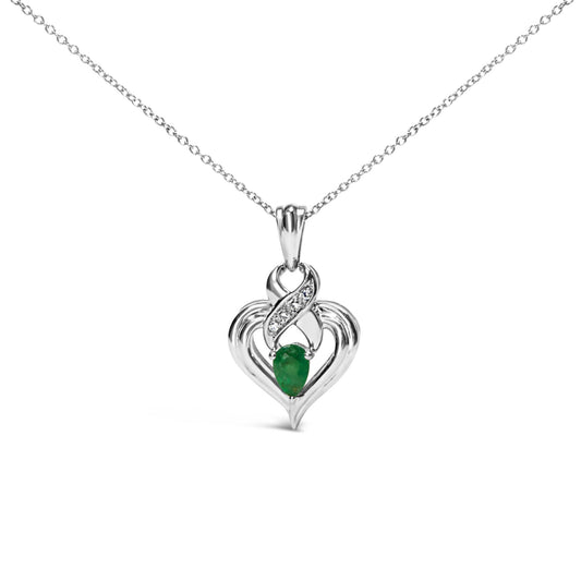 Front view of a white metal heart-shaped necklace pendant with a pear-shaped green gemstone at the center and a curved section above set with four small round white gemstones, hanging on a delicate white metal chain.