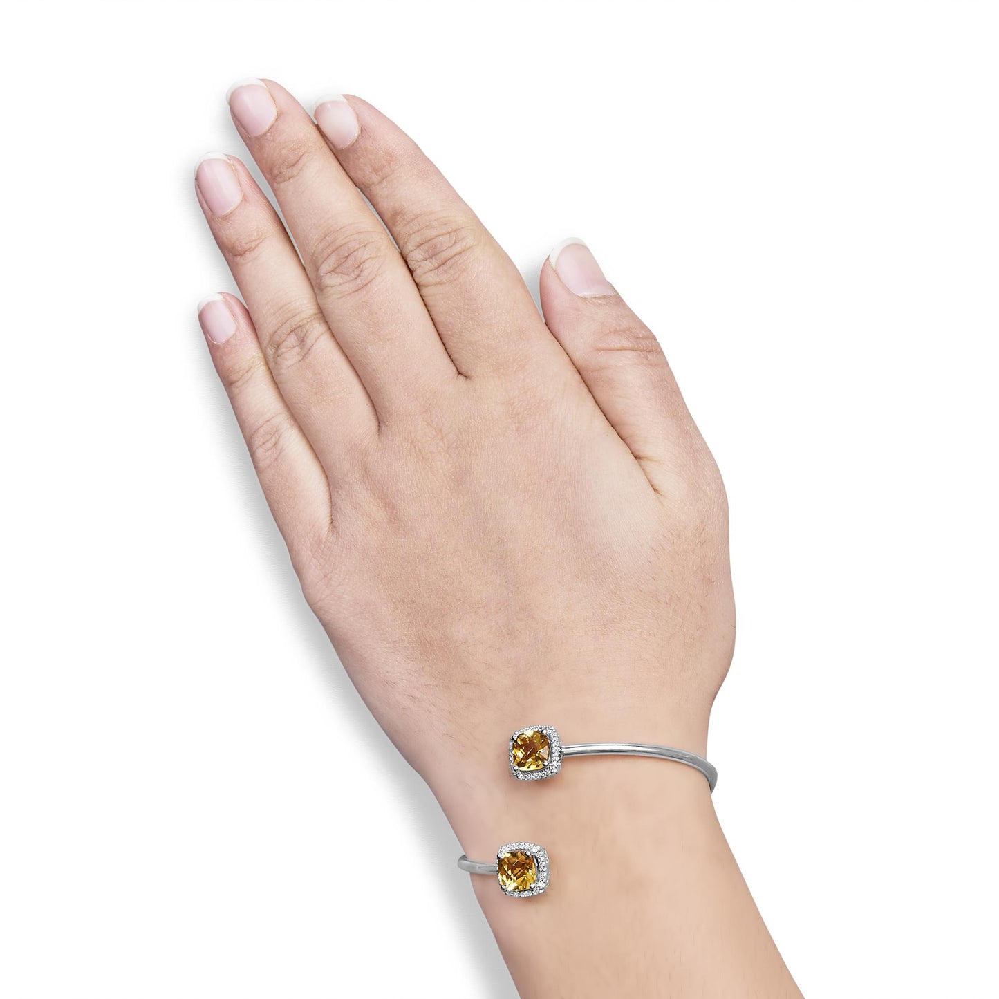 White metal open bracelet with two yellow cushion-shaped gemstones surrounded by small round white gemstones, shown on a model's wrist from top angle.