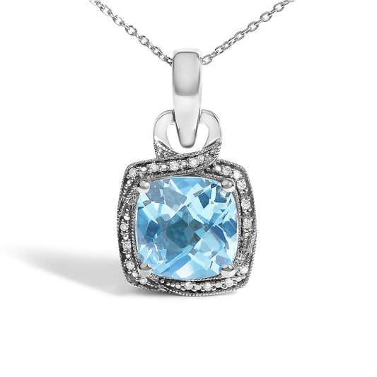Close-up front angle of a white metal necklace pendant with one large cushion-shaped blue gemstone surrounded by small round white gemstones in a prong setting.