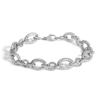 Close-up, top view of a white metal bracelet with a lobster clasp, featuring alternating large oval links accented with pave-set white gemstones and smaller textured links.