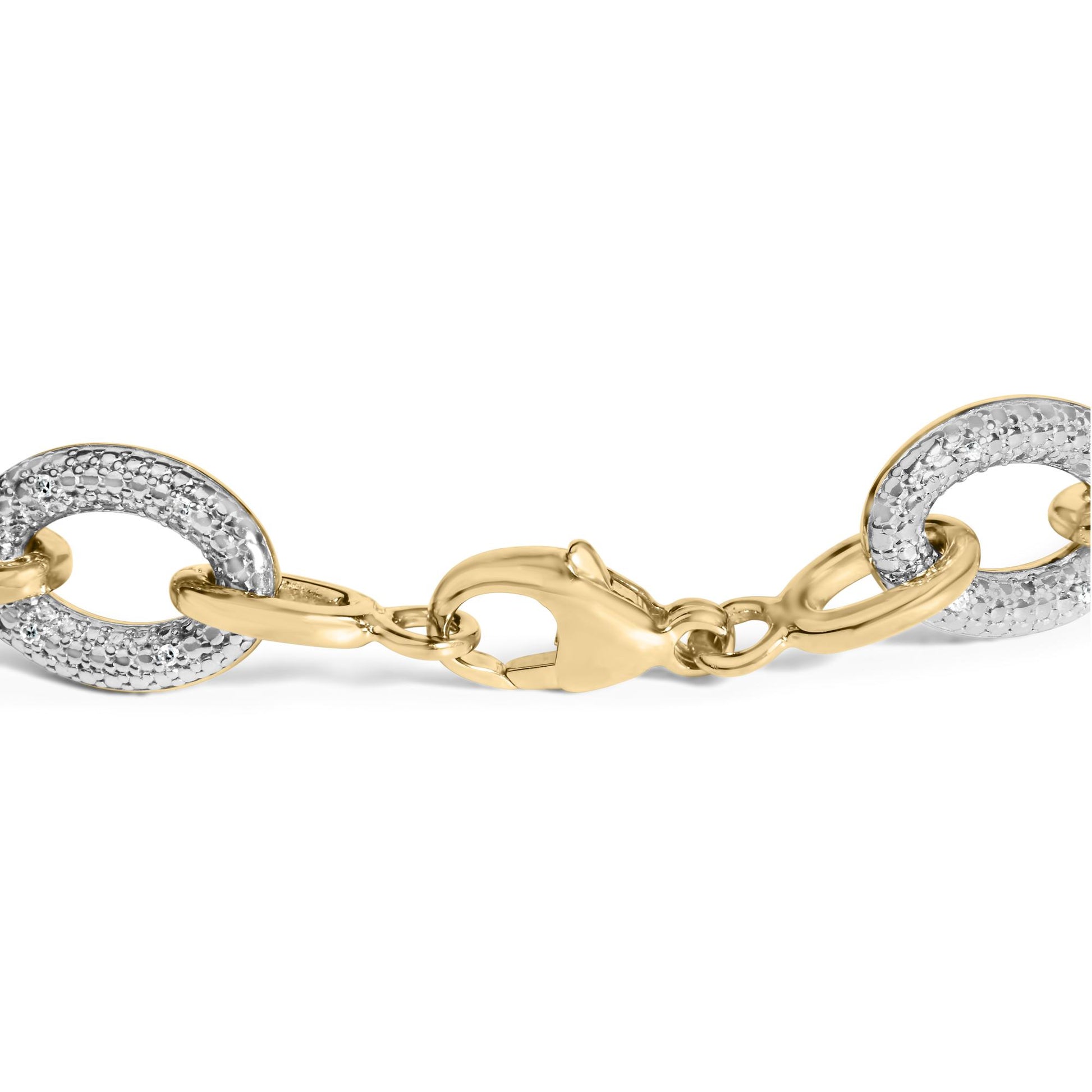 Close-up front angle of a yellow metal bracelet with oval links, some featuring white gemstones in a pave setting, shown on a white background.
