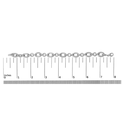 White metal bracelet with alternating large and small oval links, each large link accented with small white gemstones in a pave setting, shown flat on a ruler scale, top view.