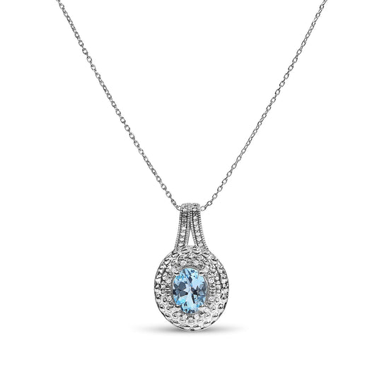 Close-up front angle of a white metal necklace with a pendant featuring an oval blue gemstone surrounded by round white gemstones in pave setting.