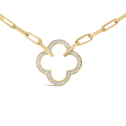 Close-up front view of a yellow metal necklace with a chain link and a clover-shaped pendant outlined with white gemstones in pave setting.