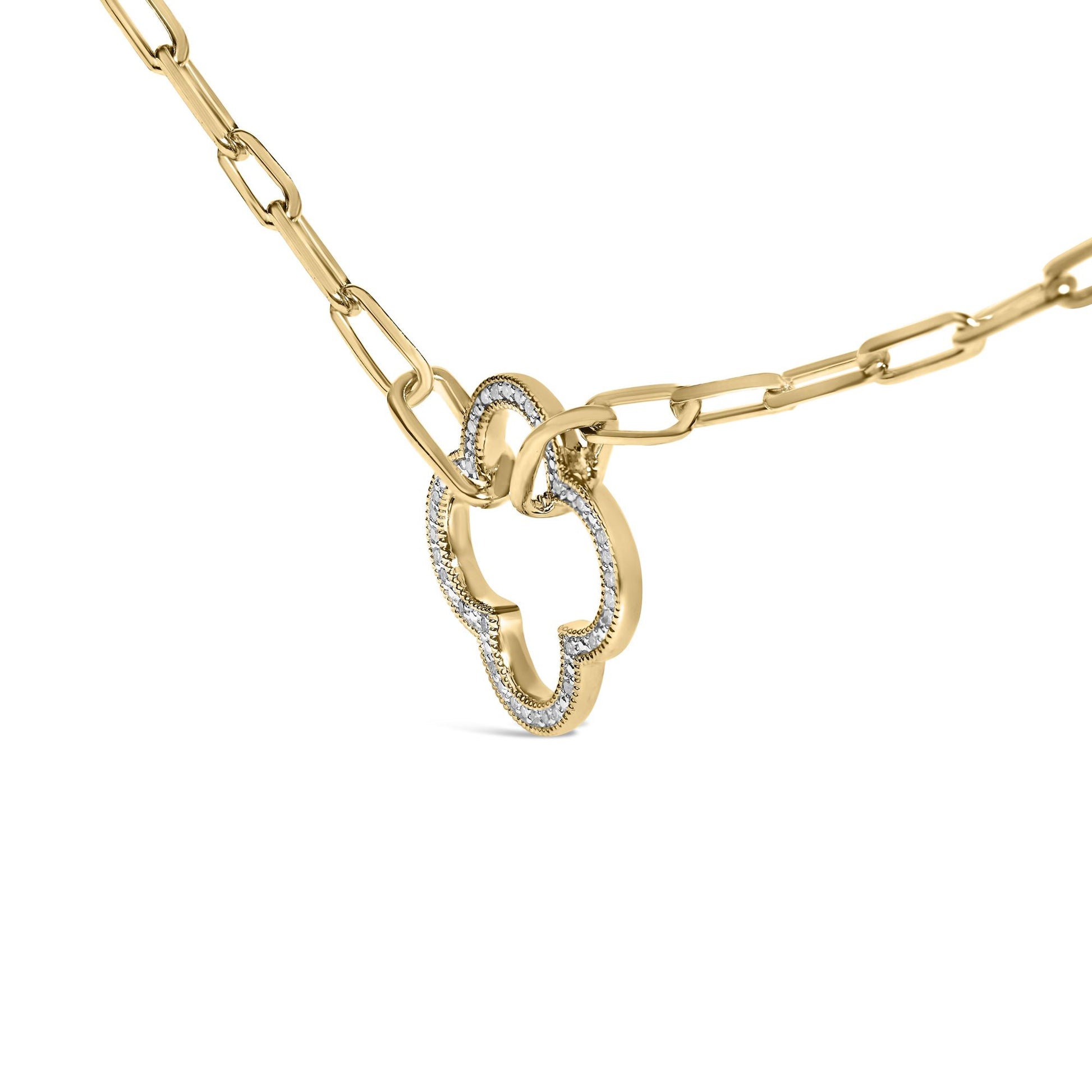 Close-up front angle of a yellow metal necklace with a linked chain featuring a pendant outlined with white gemstones in pave setting.