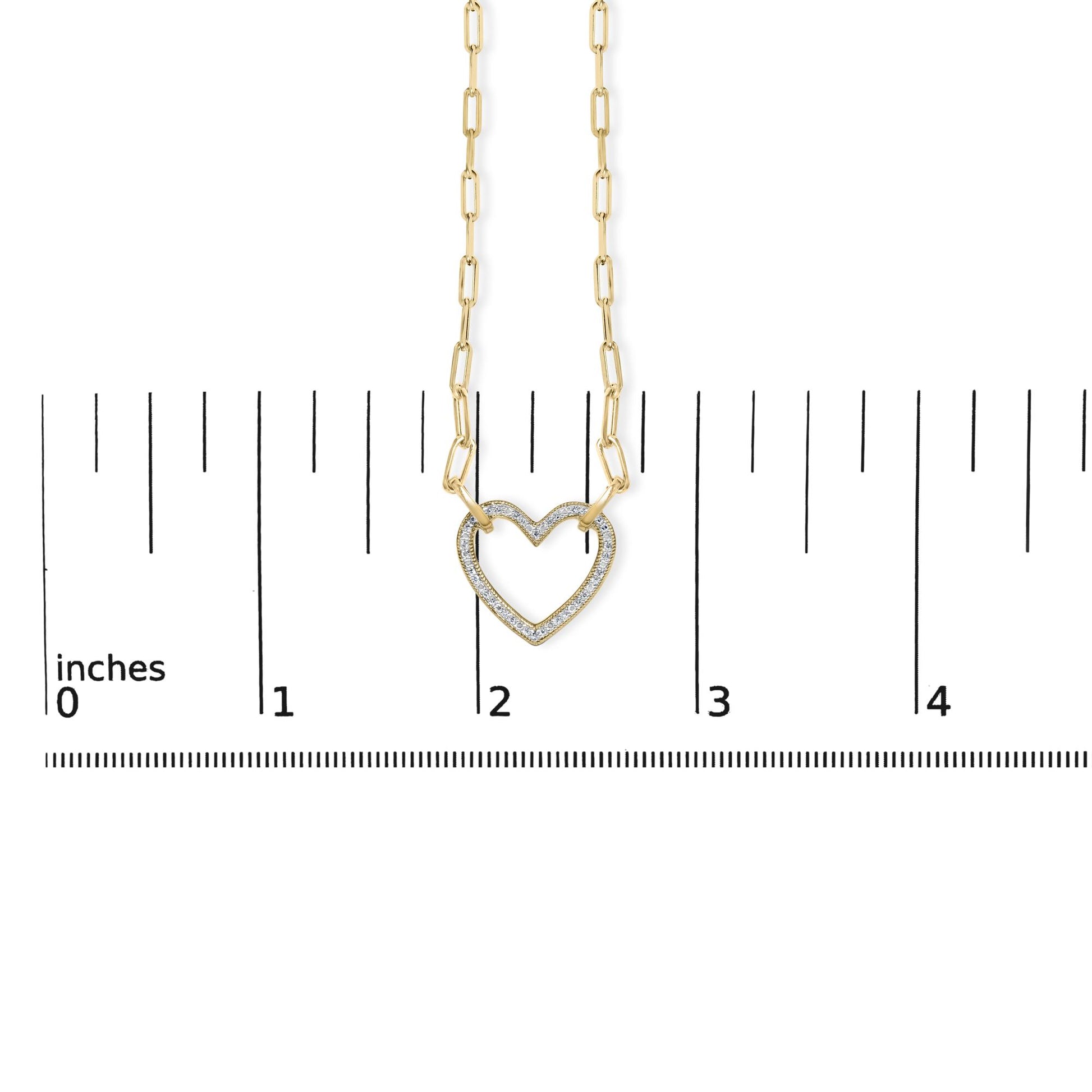 Close-up front view of a yellow necklace with a heart-shaped pendant featuring pave-set white gemstones, shown on a scale.