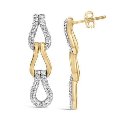 Close-up front and side views of yellow metal earrings shaped like elongated loops with white gemstones in a pave setting on the upper and lower parts of the loops.