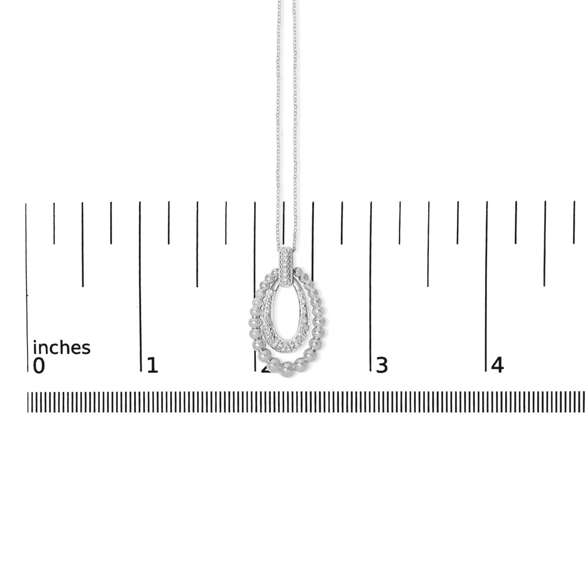 Close-up front view of a white necklace pendant with a pave setting of round white gemstones, displayed on a measurement scale.