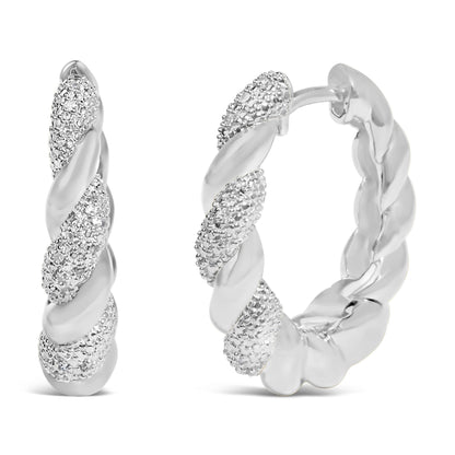 Close-up front angle of a pair of white metal twisted hoop earrings with sections featuring pave-set white gemstones.