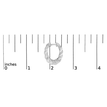 Close-up front view of a white twisted hoop earring with sections set with small white gemstones, shown on a ruler for scale.