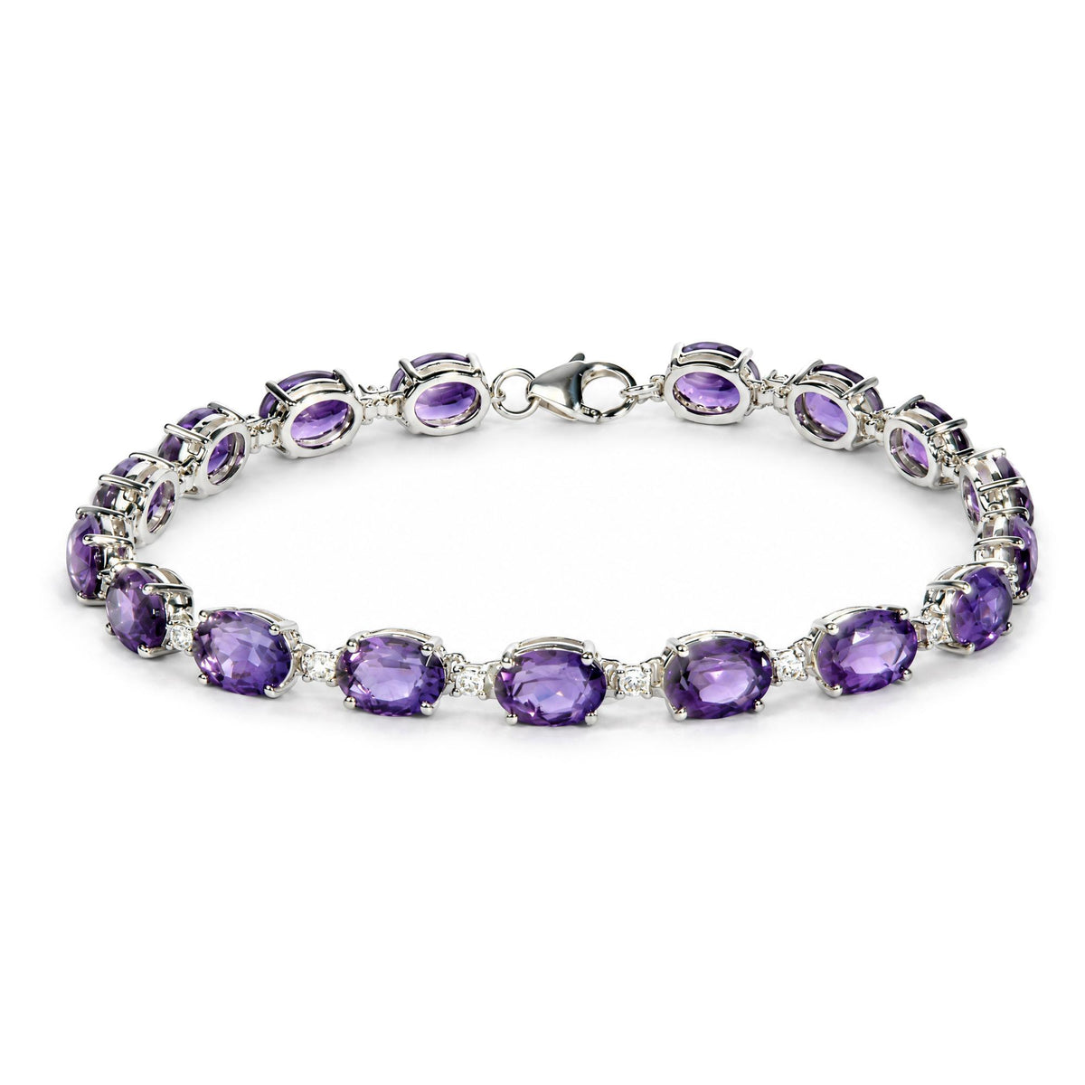 White metal bracelet with prong-set oval purple gemstones and small round white gemstones, shown on a white background from a top angled close-up.