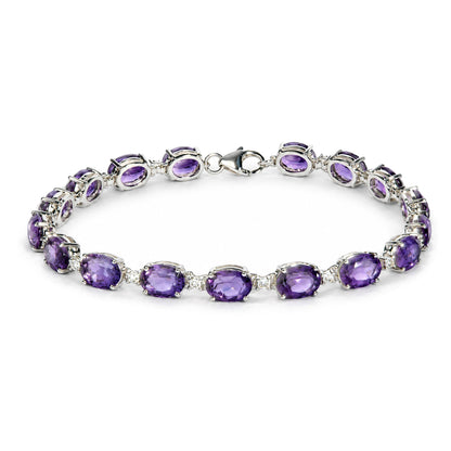 White metal bracelet with prong-set oval purple gemstones and small round white gemstones, shown on a white background from a top angled close-up.