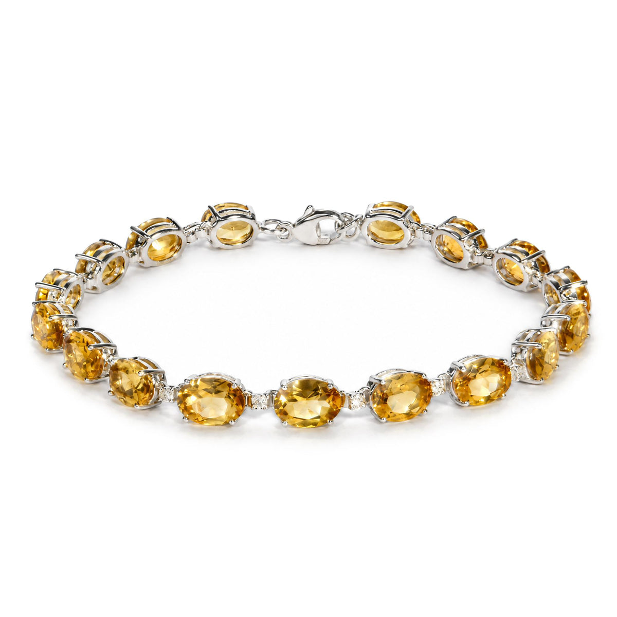 Close-up front angle of a white metal bracelet featuring oval yellow gemstones and small round white gemstones in prong settings, shown flat on a white background.