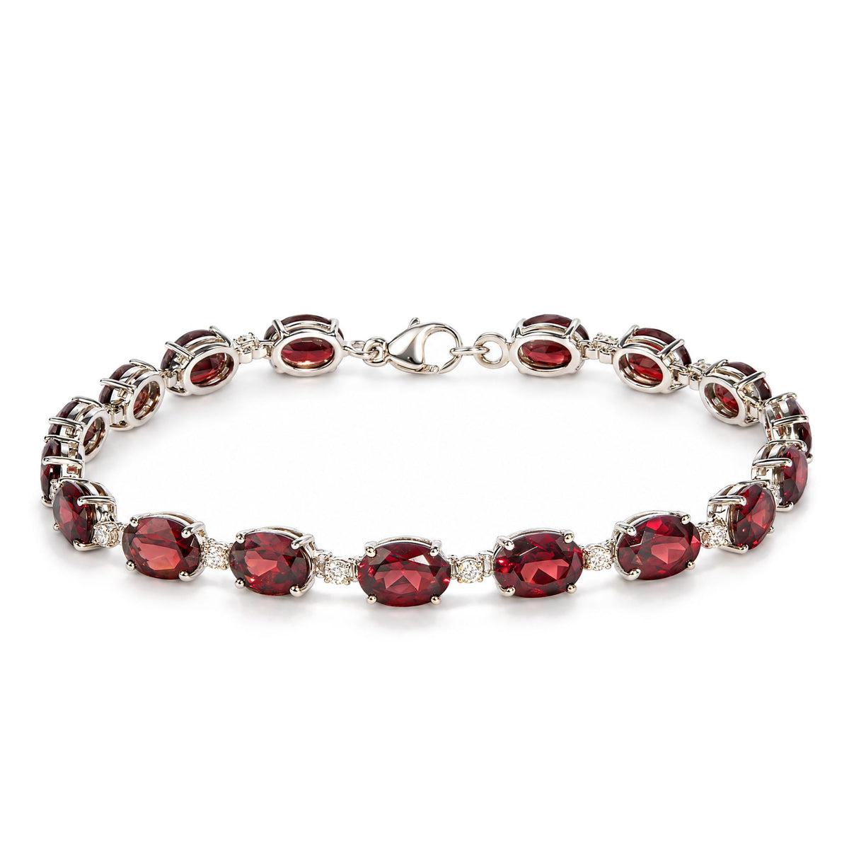Close-up front angle of a white metal bracelet with alternating oval red gemstones and small round white gemstones in prong settings, shown on a white background.