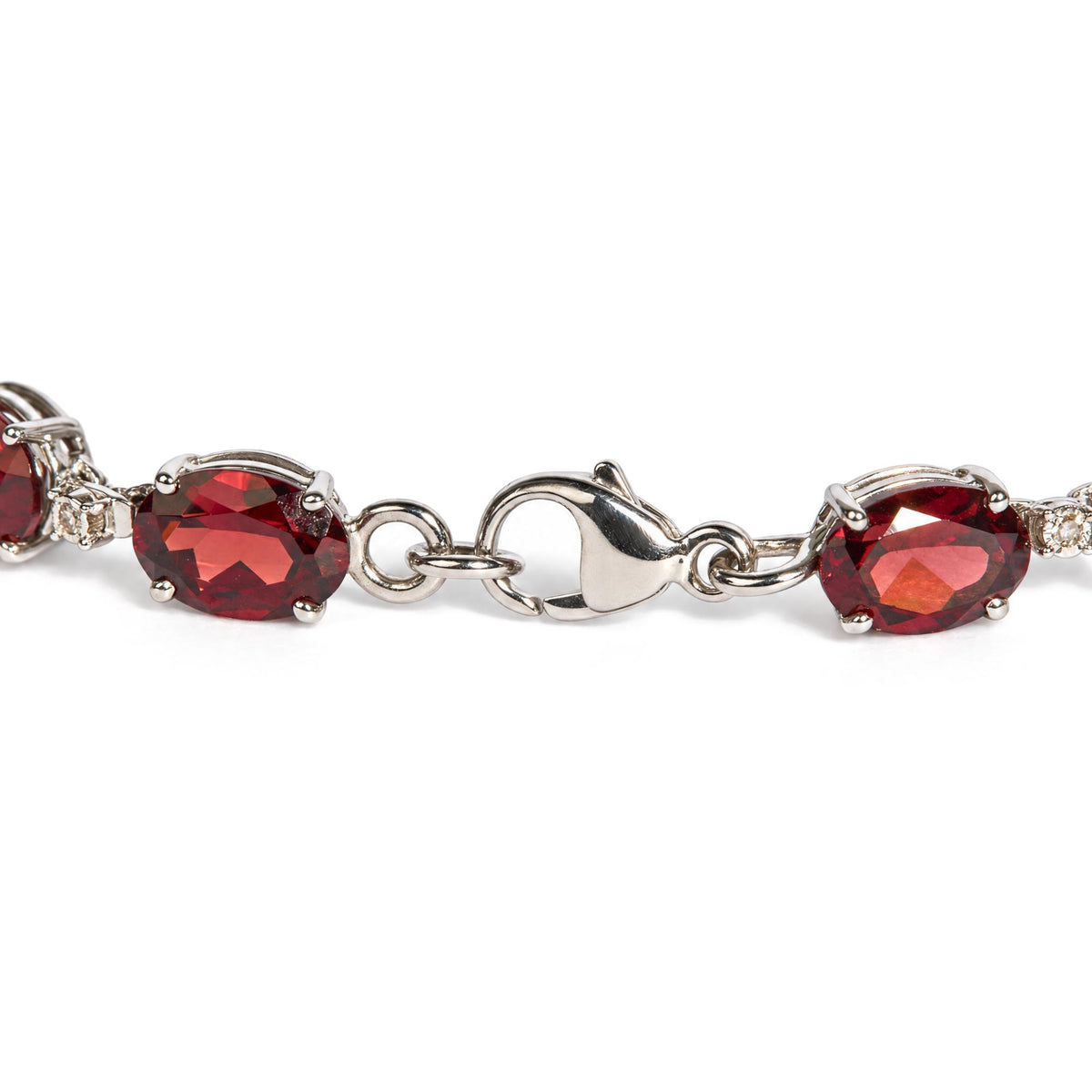 Close-up front angle of a white metal bracelet with oval red gemstones and small round white gemstones, shown on a white background.