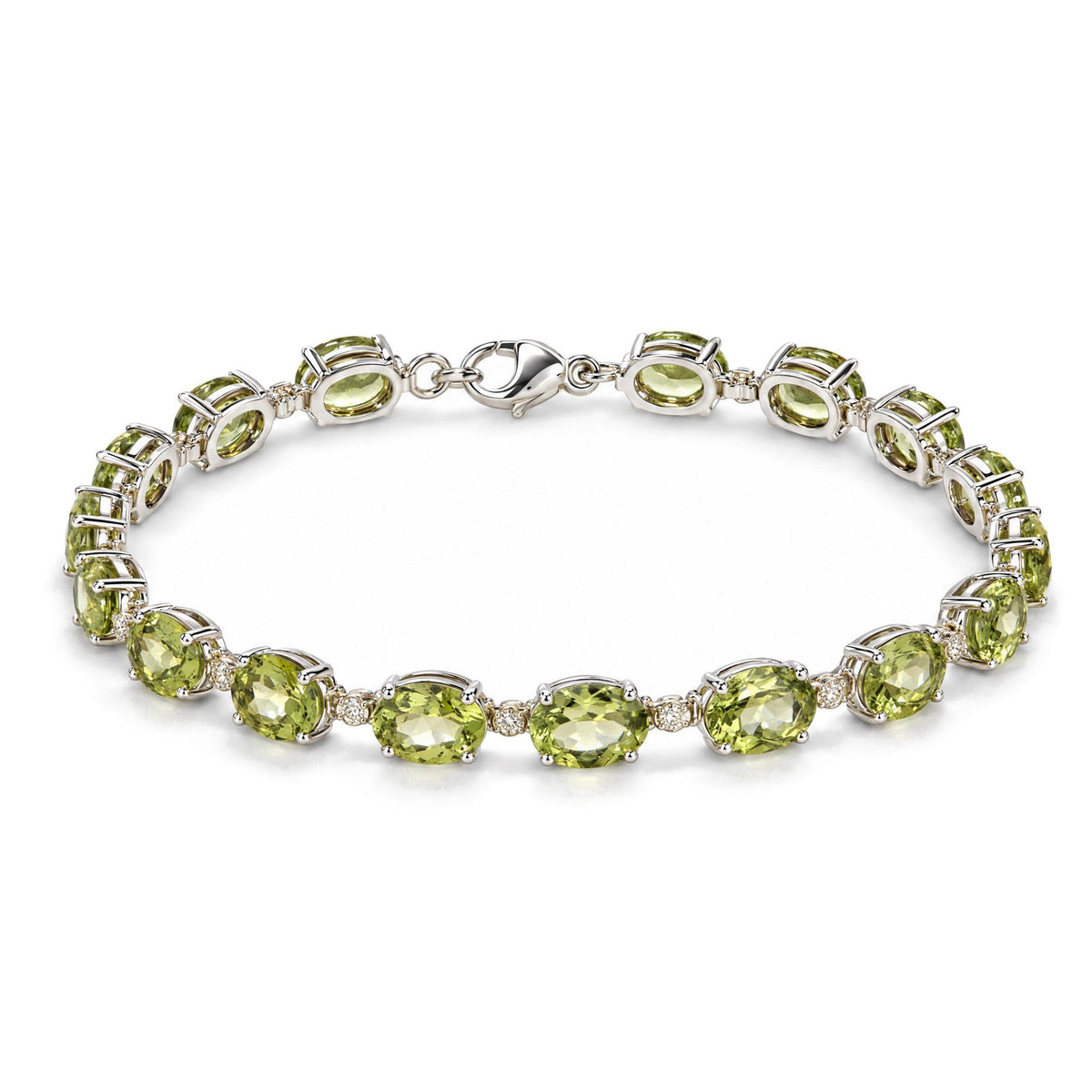 Close-up top view of a white metal bracelet with oval green gemstones and small round white gemstones in prong settings, shown on a white background.