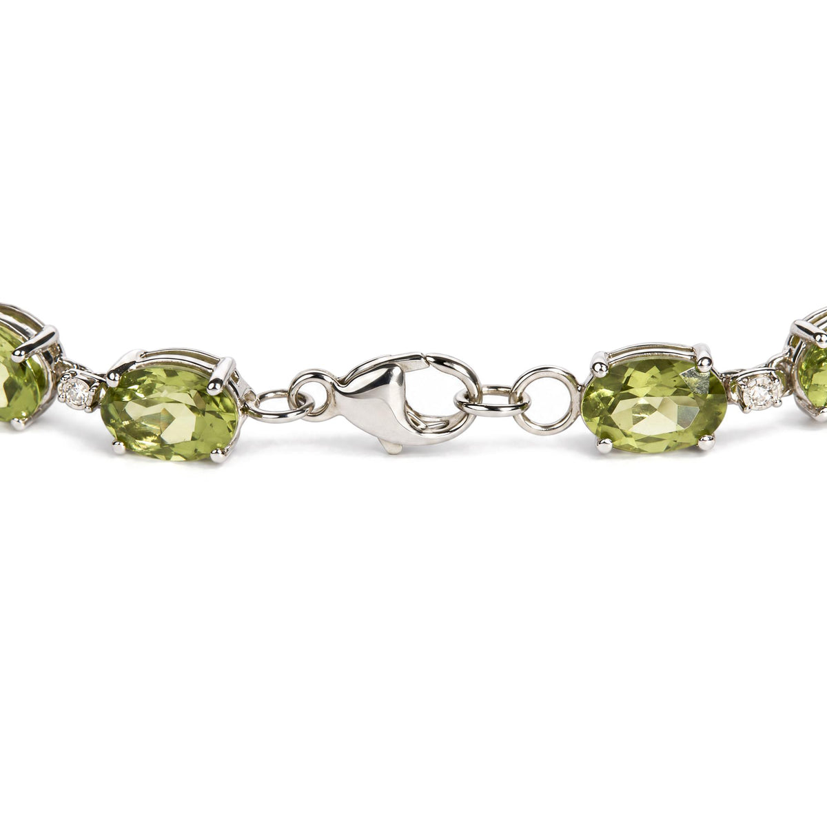 Close-up front angle of a white metal bracelet featuring oval green gemstones in prong settings alternating with small round white gemstones, shown on a white background.