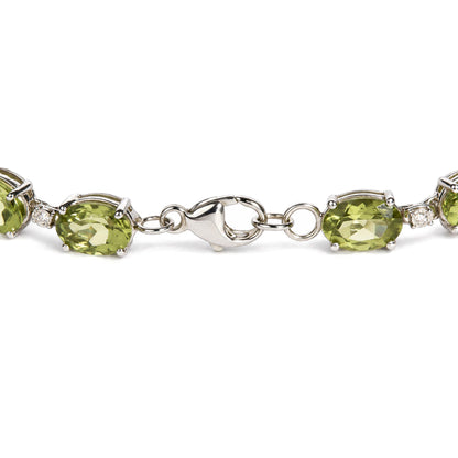 Close-up front angle of a white metal bracelet featuring oval green gemstones in prong settings alternating with small round white gemstones, shown on a white background.