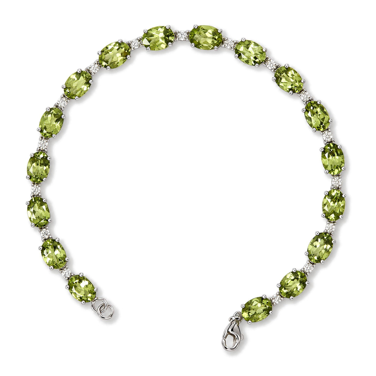 White metal bracelet with alternating oval green gemstones and round white gemstones in prong settings, shown in a close-up flat lay from above.
