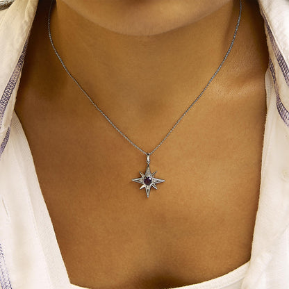 Close-up front view of a model wearing a white metal necklace with a star-shaped pendant featuring a round purple gemstone at the center and four round white gemstones in prong settings.